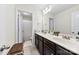 Bathroom featuring double sinks with dark wood cabinetry and tile flooring, plus a doorway to a separate toilet and shower room at 4866 Breden St, Kannapolis, NC 28081