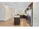 Open-concept kitchen with island, stainless appliances, and access to the living area with fireplace at 4866 Breden St, Kannapolis, NC 28081