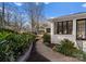 Serene backyard featuring a stone pathway surrounded by lush greenery and a white brick exterior at 5630 Timber Ln, Charlotte, NC 28270