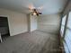 A well-lit bedroom with a ceiling fan, large windows, and neutral-colored walls at 5934 Hickory Hollow Ct, Harrisburg, NC 28075