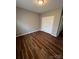 Bedroom with wood-look flooring, neutral walls, and double door closet at 5934 Hickory Hollow Ct, Harrisburg, NC 28075