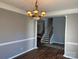Dining area with an elegant chandelier, crown molding, and wood-look flooring at 5934 Hickory Hollow Ct, Harrisburg, NC 28075