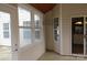 Enclosed porch with tile flooring, multiple windows, and a sliding glass door to the inside at 5934 Hickory Hollow Ct, Harrisburg, NC 28075