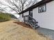 Side entrance of the white home featuring black door, black framed windows and gray stairs at 7514 Highway 205 Hwy, Marshville, NC 28103