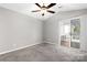 Bright bedroom with a ceiling fan, carpet flooring, and a sliding glass door leading to outdoor patio at 753 Southwest Dr, Davidson, NC 28036