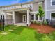 A backyard featuring a covered patio, small lawn, and landscaping, creating a cozy outdoor space at 10115 Mamillion Dr, Huntersville, NC 28078