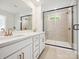 Modern bathroom featuring a double vanity with white cabinets, gold hardware, and a large glass-enclosed shower at 10115 Mamillion Dr, Huntersville, NC 28078