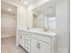 Bathroom featuring double vanity with white cabinets and gold hardware, with a large mirror and walk-in closet at 10115 Mamillion Dr, Huntersville, NC 28078