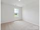 Bedroom with neutral carpet, white walls, and a window offering a view of the outside at 10115 Mamillion Dr, Huntersville, NC 28078