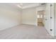 A spacious bedroom with neutral carpet, a tray ceiling, and a doorway leading to other parts of the home at 10115 Mamillion Dr, Huntersville, NC 28078