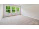 Carpeted bedroom filled with natural light from three large windows overlooking lush greenery at 10115 Mamillion Dr, Huntersville, NC 28078