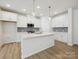 Modern kitchen featuring white cabinets, stainless appliances, an island, and stylish pendant lighting at 10115 Mamillion Dr, Huntersville, NC 28078