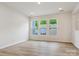 Bright living room featuring three large windows offering ample natural light and wood-look flooring at 10115 Mamillion Dr, Huntersville, NC 28078