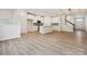 Spacious living area showcasing an island kitchen, staircase, and stylish wood-look flooring throughout the home at 10115 Mamillion Dr, Huntersville, NC 28078