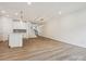 Open concept living and kitchen area boasts modern lighting, a kitchen island, and wood-look flooring at 10115 Mamillion Dr, Huntersville, NC 28078