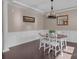 Traditional dining room with hardwood floors, decorative wainscoting, and a stylish chandelier at 1148 Mckee Farm Ln, Belmont, NC 28012