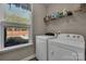Convenient laundry room with a washer, dryer, shelving, and natural light at 1148 Mckee Farm Ln, Belmont, NC 28012