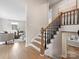 Inviting foyer featuring hardwood floors, wooden staircase, and views into the living spaces at 122 Lansdowne Rd, Charlotte, NC 28270