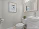 Bright powder room featuring a stylish vanity, toilet, and decorative wall art at 122 Lansdowne Rd, Charlotte, NC 28270