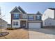 Charming two-story home featuring a brick facade, attached garage, and manicured front yard at 124 Doncaster Dr, Mooresville, NC 28115