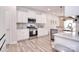 This modern kitchen boasts stainless steel appliances, white cabinets, and wood-look flooring at 124 Doncaster Dr, Mooresville, NC 28115