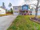 Two-story house with tan and blue siding, a two-car garage, and a well-manicured lawn at 12440 Stowe Acres Dr, Charlotte, NC 28262