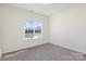 Neutral bedroom featuring a large window and neutral carpet at 132 Elizabeth Hearth Rd, Mooresville, NC 28115