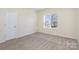 Neutral bedroom with carpet, cream walls, and a large window showing the neighborhood at 132 Elizabeth Hearth Rd, Mooresville, NC 28115