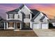 Traditional two-story home with a three-car garage, black shutters and inviting front porch at 132 Elizabeth Hearth Rd, Mooresville, NC 28115