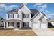 Traditional two-story home with a three-car garage, black shutters and inviting front porch at 132 Elizabeth Hearth Rd, Mooresville, NC 28115