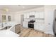 New modern kitchen with white cabinets, stainless appliances, granite countertops, and light wood floors at 132 Elizabeth Hearth Rd, Mooresville, NC 28115