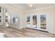 Bright living room featuring light wood floors, large windows, and French doors to the backyard at 132 Elizabeth Hearth Rd, Mooresville, NC 28115