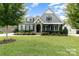 Gray two-story house with stone accents, landscaped yard, and a three-car garage at 1320 Torrens Dr, Wesley Chapel, NC 28110