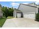 Three-car garage with white doors and landscaping at 1320 Torrens Dr, Wesley Chapel, NC 28110
