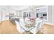 Open-concept dining area featuring a glass table, white chairs, and backyard views at 15700 Youngblood Rd, Charlotte, NC 28278