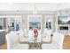 Dining room with glass table, sleek white chairs, and backyard access to the pool at 15700 Youngblood Rd, Charlotte, NC 28278
