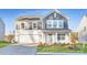 Two-story house with gray and white siding, a white garage door, and landscaping at 1715 Wooten Way, Bessemer City, NC 28016
