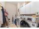 Laundry room featuring a front load washer and dryer with storage cabinets at 3302 Cole Mill Rd, Charlotte, NC 28270