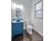 Stylish half-bath with a blue vanity, vessel sink, modern fixtures, and a round mirror at 375 Montibello Dr, Mooresville, NC 28117