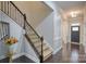 Elegant foyer showcasing a staircase with wrought iron spindles, hardwood floors, and stylish entry door with sidelights at 375 Montibello Dr, Mooresville, NC 28117