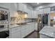 Bright kitchen showcases stainless steel appliances, white cabinetry, granite counters, and a tile backsplash at 375 Montibello Dr, Mooresville, NC 28117