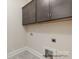 Functional laundry room featuring gray cabinets, ample storage, and convenient utility connections at 4021 Harmattan Dr, Denver, NC 28037