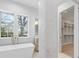 A well-lit bathroom with a contemporary tub, marble accents, and a glimpse into the walk-in closet at 722 Hillside Ave, Charlotte, NC 28209