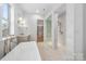 Bright bathroom featuring a modern tub, glass-enclosed shower, and access to a walk-in closet at 722 Hillside Ave, Charlotte, NC 28209
