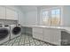 Functional laundry room with modern washer and dryer, ample counter space, and stylish tile flooring at 722 Hillside Ave, Charlotte, NC 28209