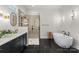 Stylish bathroom featuring a sleek vanity, a soaking tub, and a glass-enclosed shower, designed for relaxation at 831 Naples Dr, Davidson, NC 28036