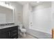 Bright bathroom with a white tub/shower combo, granite vanity, and modern fixtures at 831 Naples Dr, Davidson, NC 28036