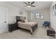 This modern bedroom features a ceiling fan, dark wood trim, and a decorative circular mirror at 831 Naples Dr, Davidson, NC 28036
