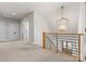 Bright hallway with modern lighting and a wood and metal railing, offering a stylish transition between spaces at 831 Naples Dr, Davidson, NC 28036