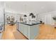Open concept kitchen featuring a large island, stainless steel appliances, and hardwood floors at 831 Naples Dr, Davidson, NC 28036